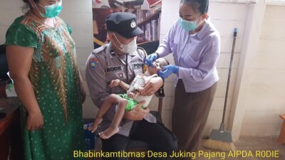 Bhabinkamtibmas Desa Juking Pajang Gendong Balita Dengan Kurang Gizi Untuk Diberikan Vitamin